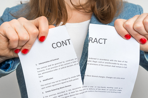 Business woman tearing contract in office – breaking contract resilição unilateral imotivada